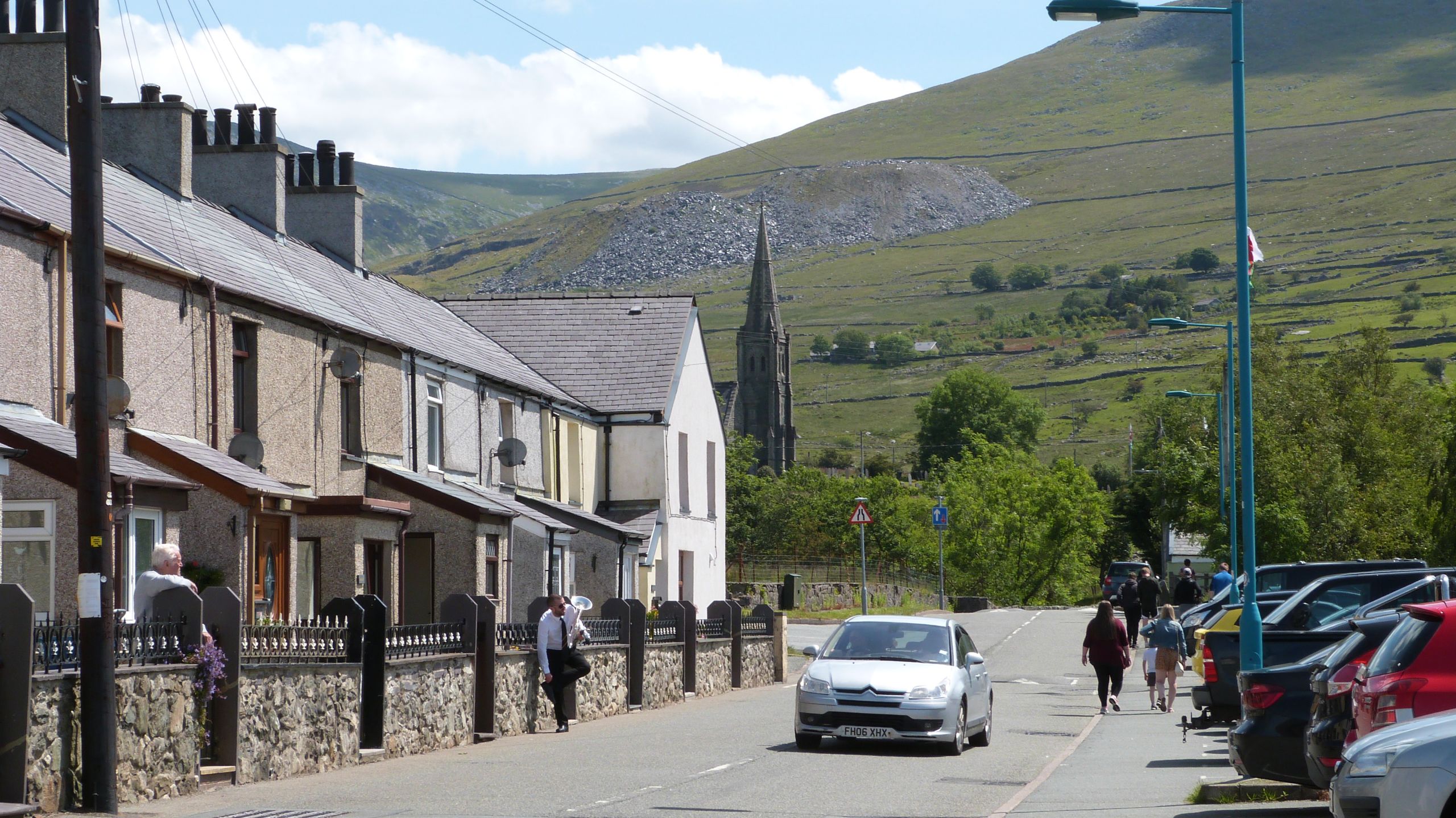 Aelod o'r seindorf yn sgwrsio gyda rhywun mewn car