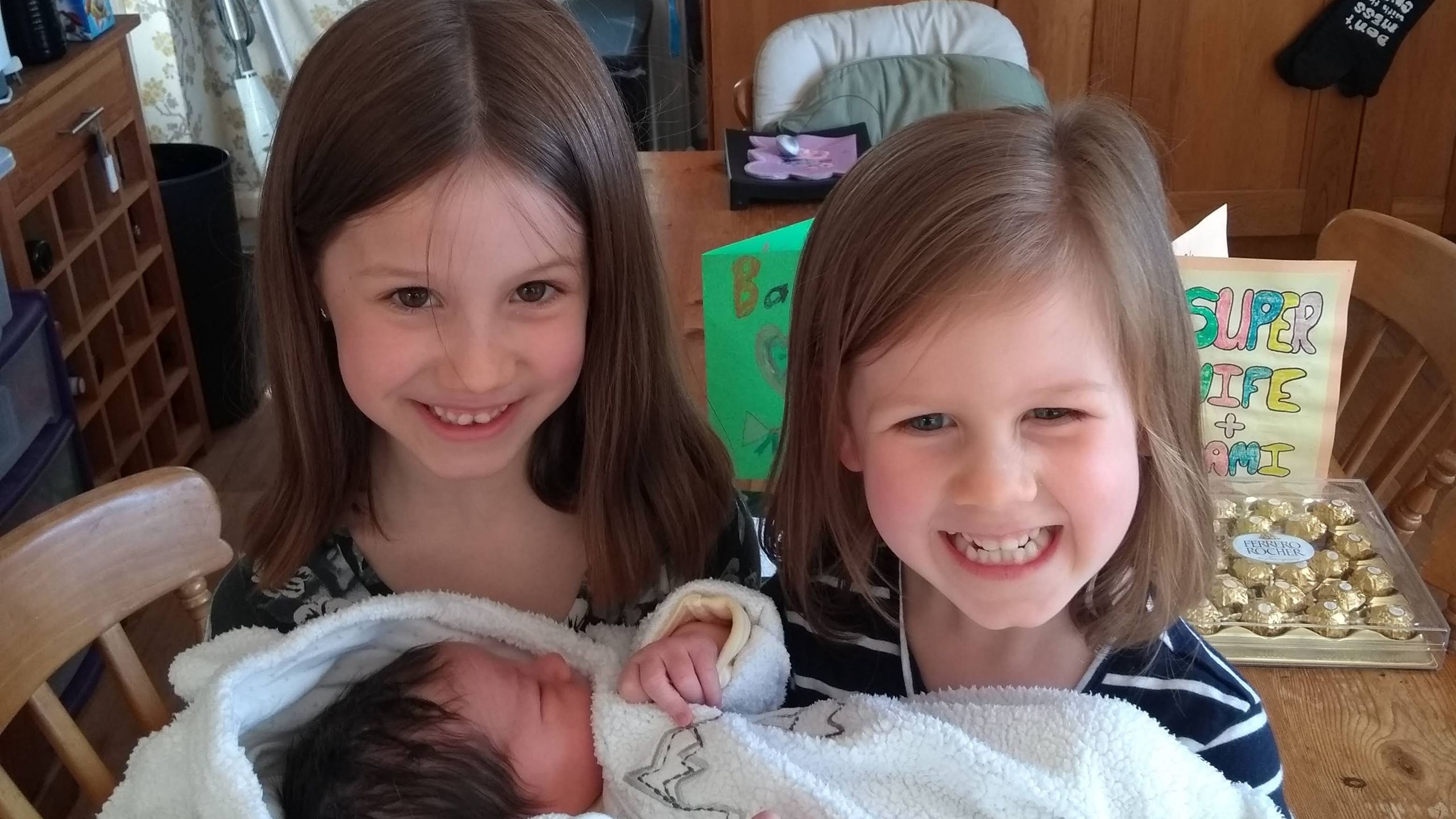 Y baban newydd gyda'i ddwy chwaer