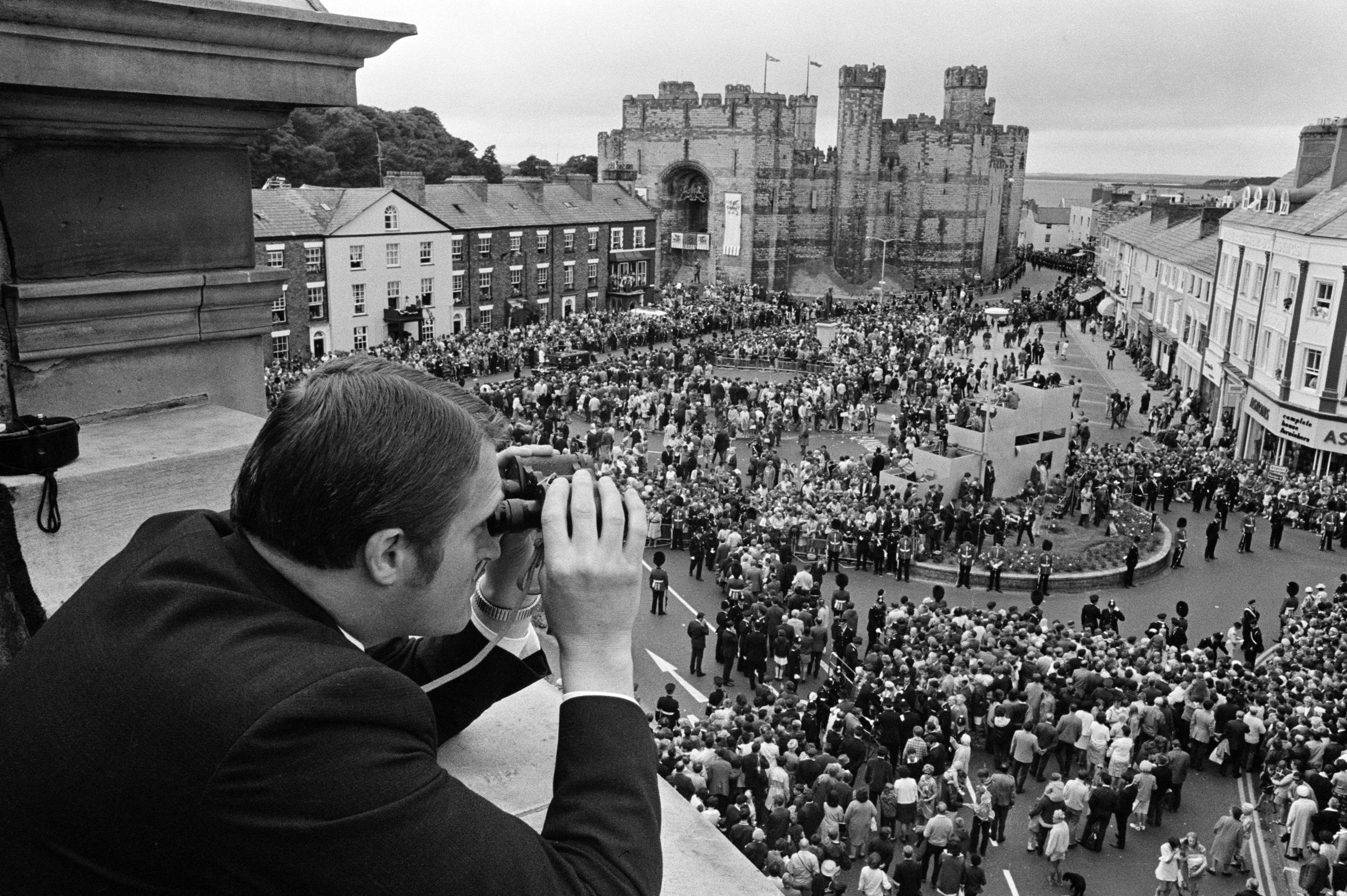 Swyddog diogelwch yn cadw llygaid ar y dorf gyda'i sbienddrych