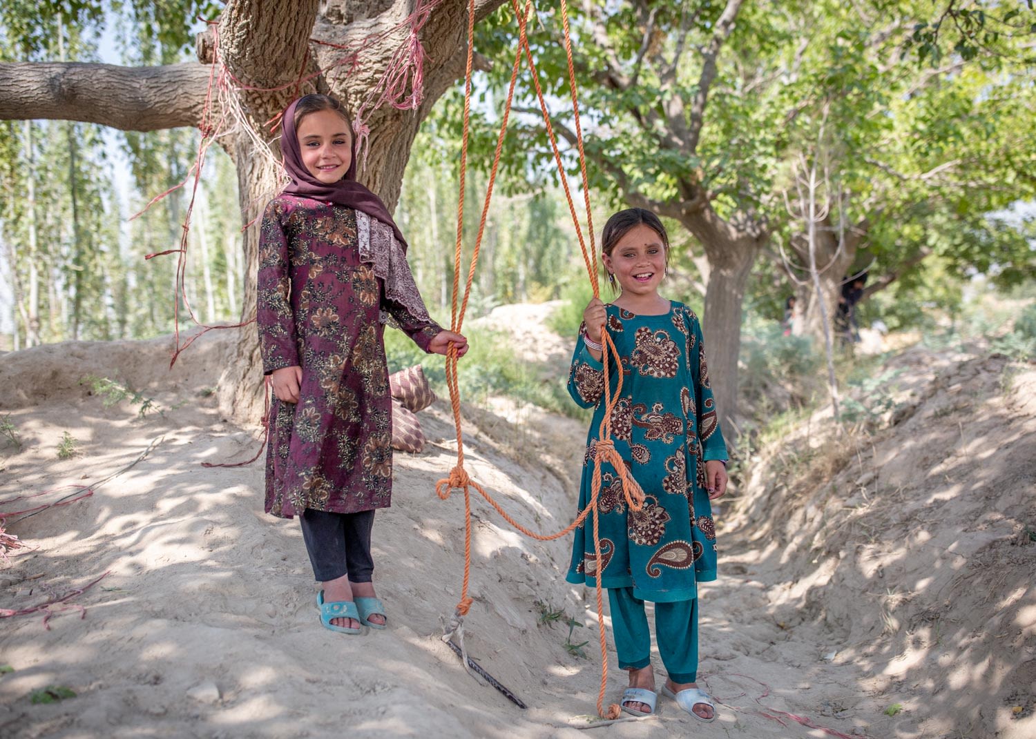 Two of Qari Sayed Muhammed's four daughters play on a homemade swing