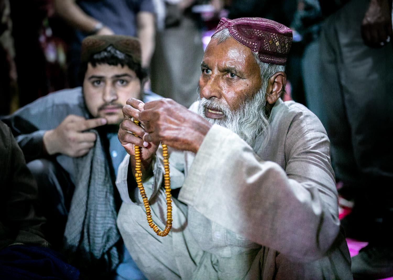 An elderly Talib holding his prayer beads