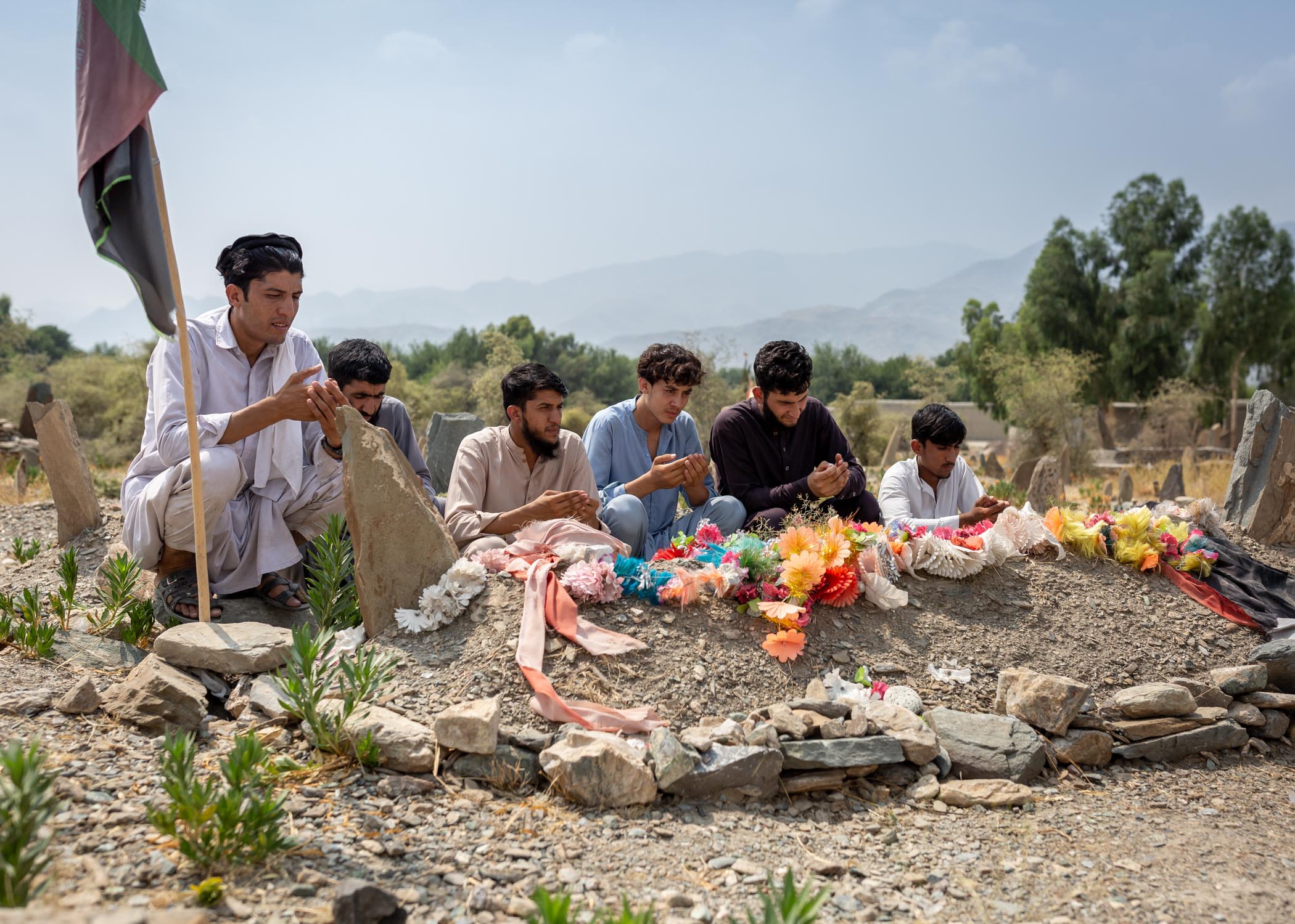 Nematullah with his family at the graveside of the unknown solider buried in his place