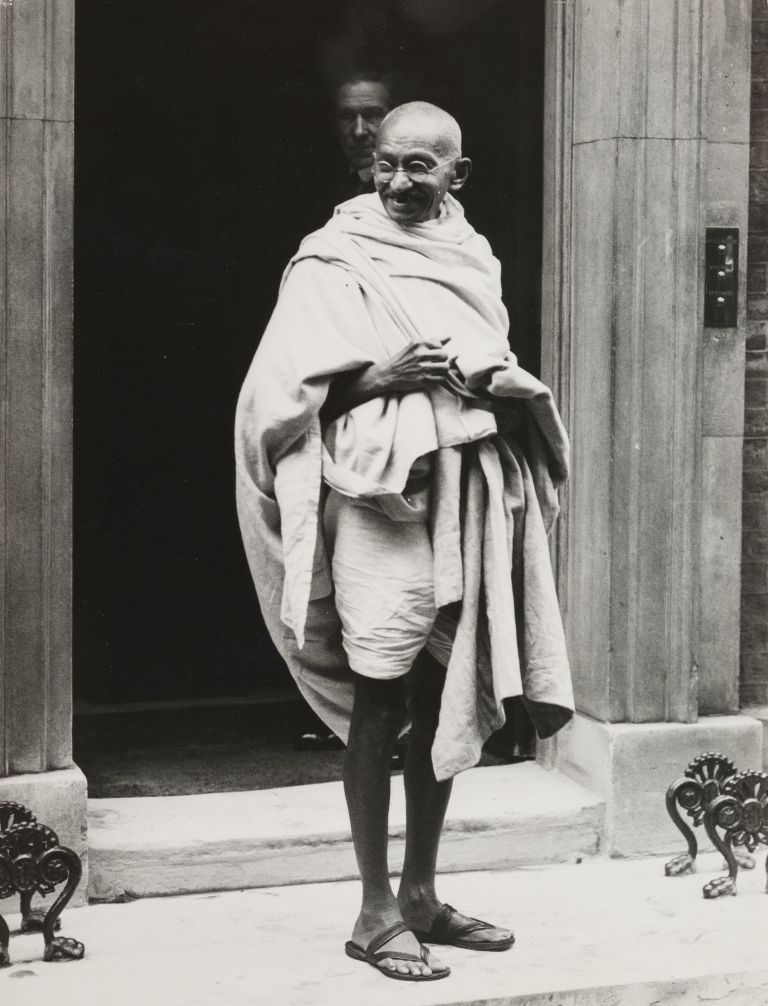 महात्मा गांधी दूसरे गोलमेज़ सम्मेलन में हिस्सा लेने के लिए 1931 में लंदन पहुंचे. यहां वो ब्रितानी प्रधानमंत्री रामसे मैकडोनल्ड से मुलाक़ात के बाद, 13 डाउनिंग स्ट्रीट से बाहर निकल रहे हैं.