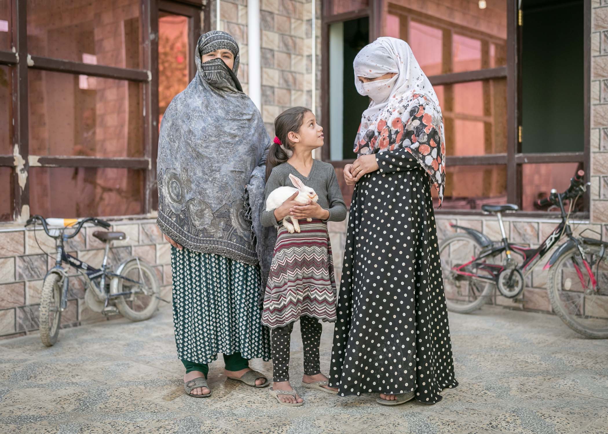 Sola holding a rabbit(C) with her Mother-in-law (L) and her mother Nargis (R)