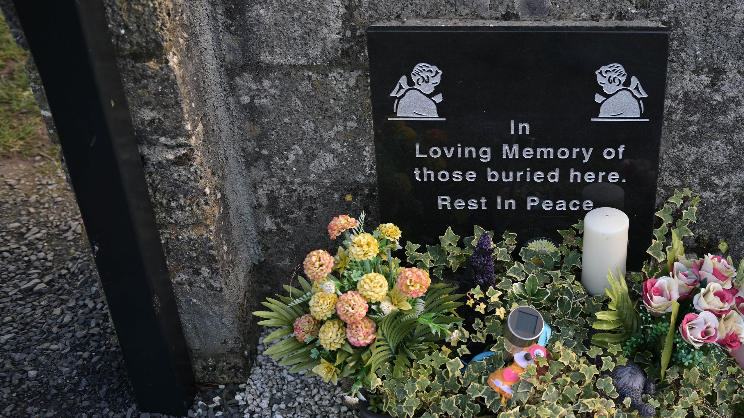 Grave stone with memorial saying 'In loving memory of those buried here. Rest in Peace'