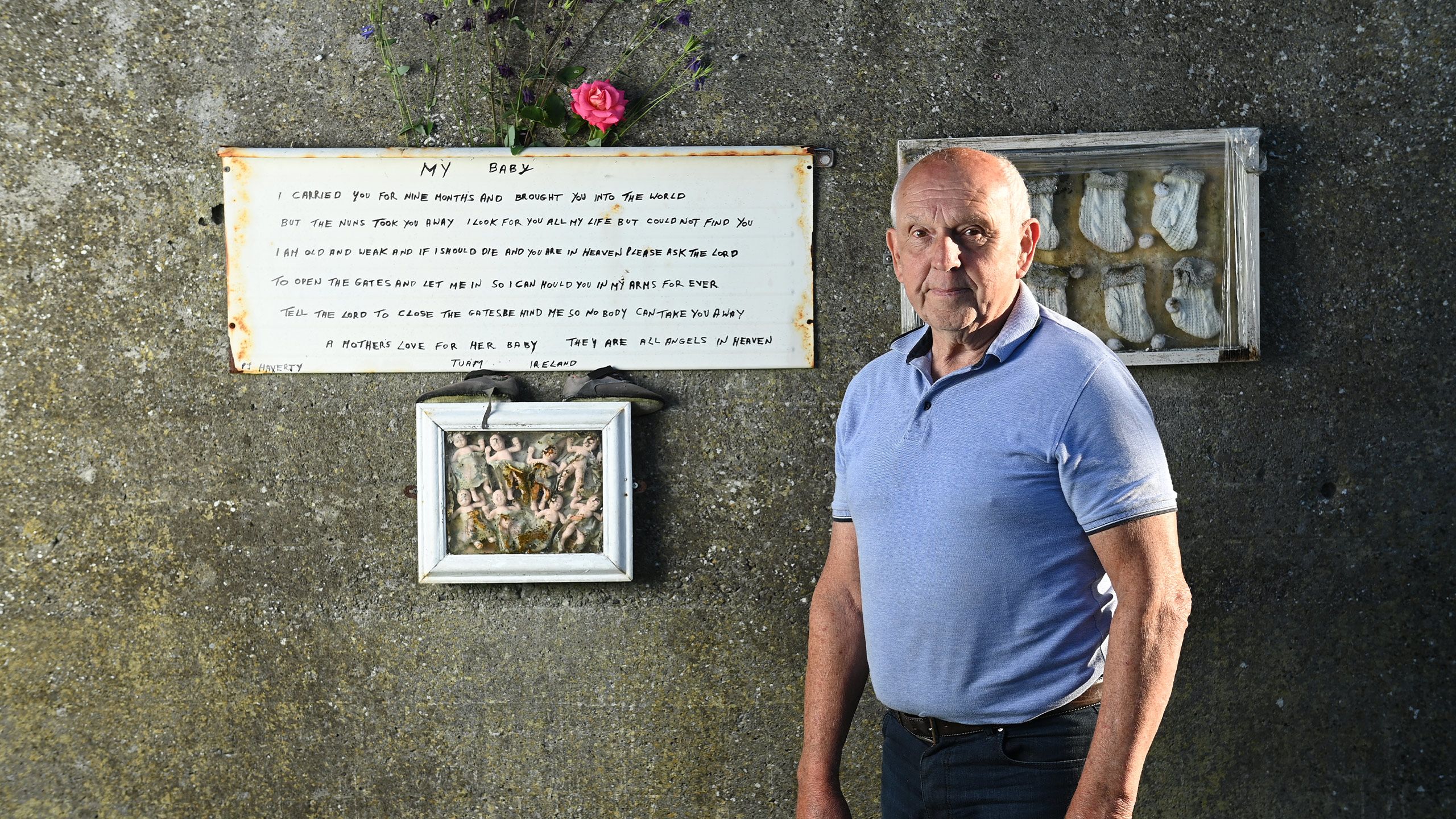 PJ Haverty pictured against a brick wall. He is an older man with short white hair and is wearing a light blue shirt.