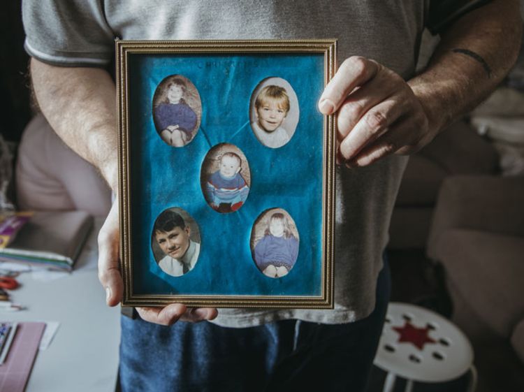 Graeme holds the only surviving frame of photos of his children