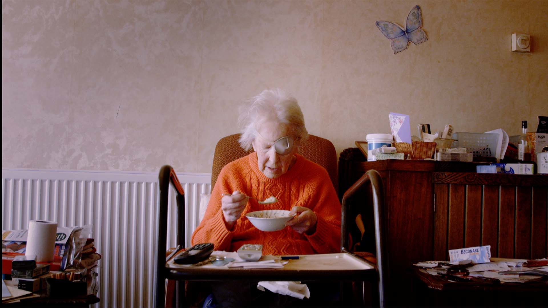 Pat eats her breakfast at a table