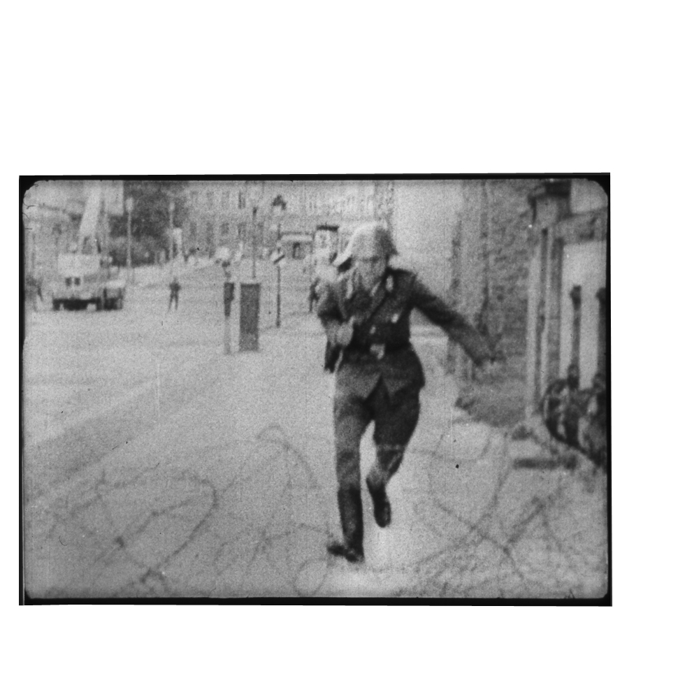 19-year-old, East German border guard Conrad Schumann jumps over barbed wire  to West Berlin on 15 August 1961. 