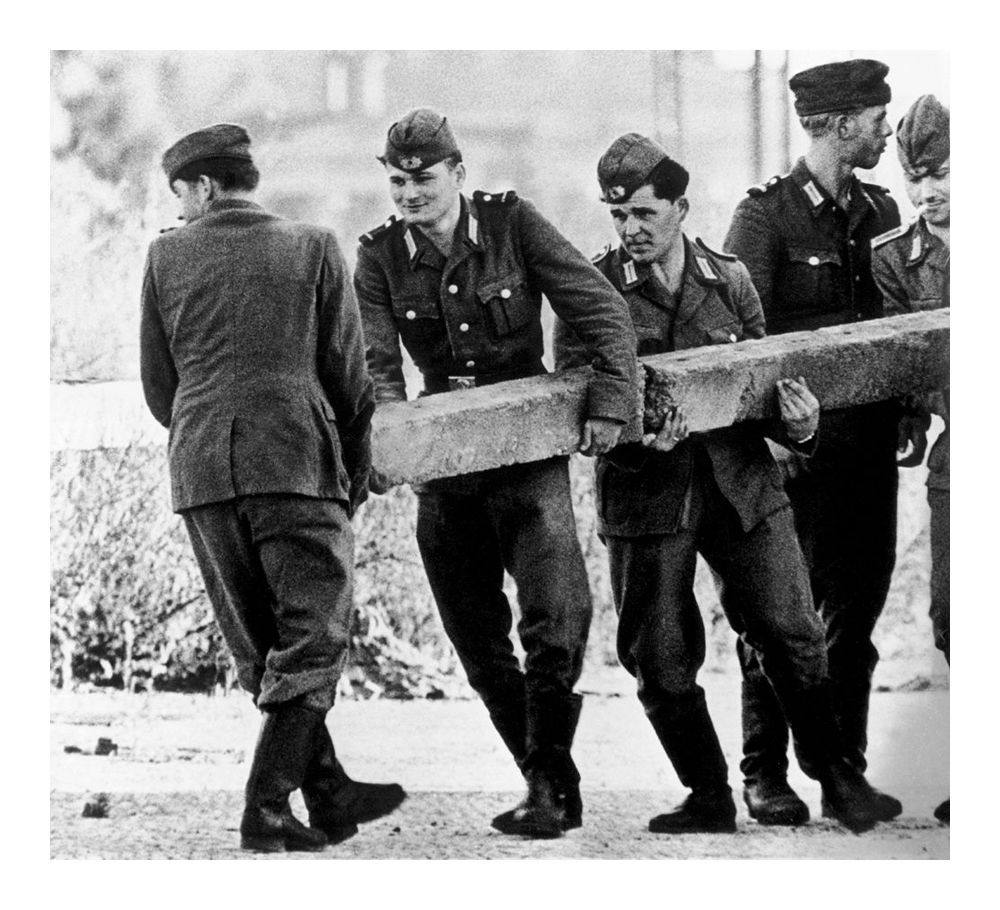 East German soldiers build the Berlin Wall and close access to West Berlin, 1961.