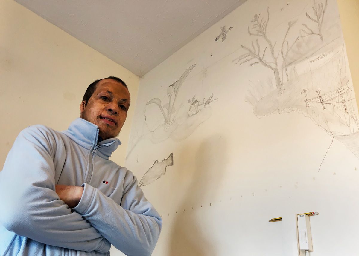 Amar with the drawings on his wall