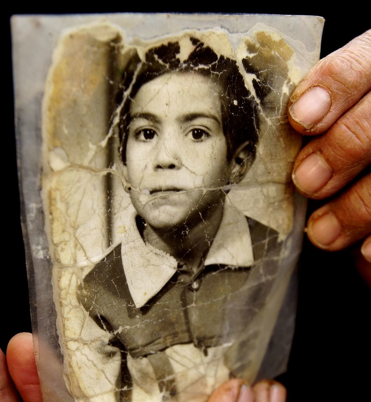 Crumpled photo of Amar as a young boy before his injuries