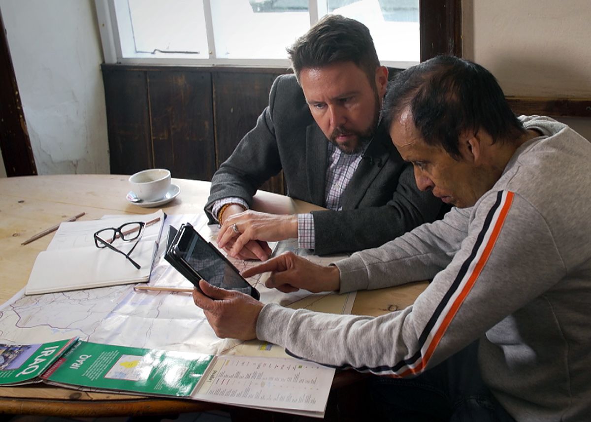 Amar with Jon Kay looking over documents and maps