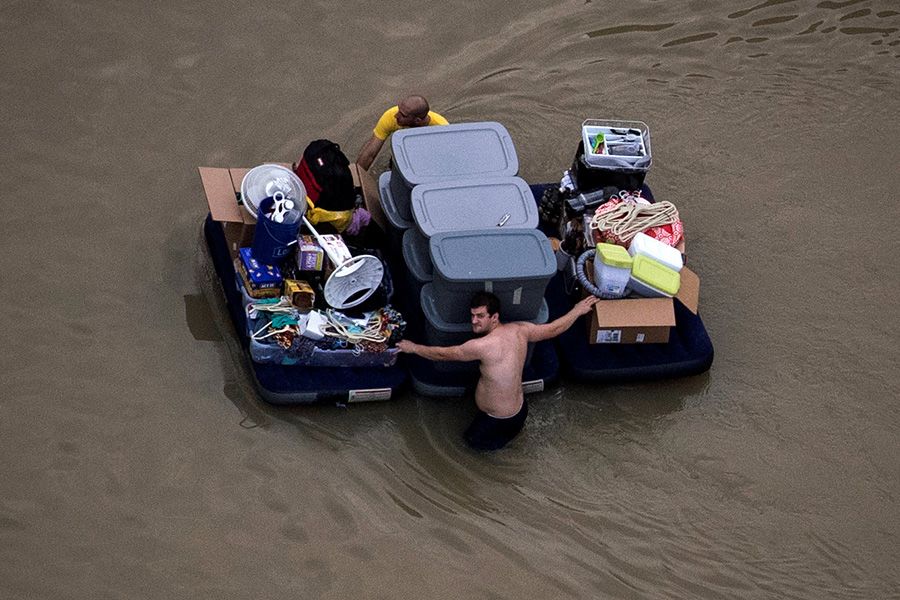 Residents wade with their belongings through flood waters after Harvey hits Texas, August 2017. Reuters