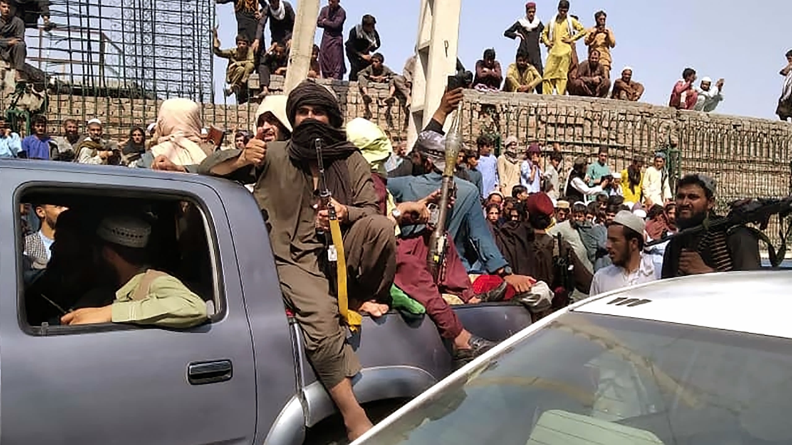 Taliban fighters sit on a vehicle along the street in Jalalabad province on August 15, 2021. 