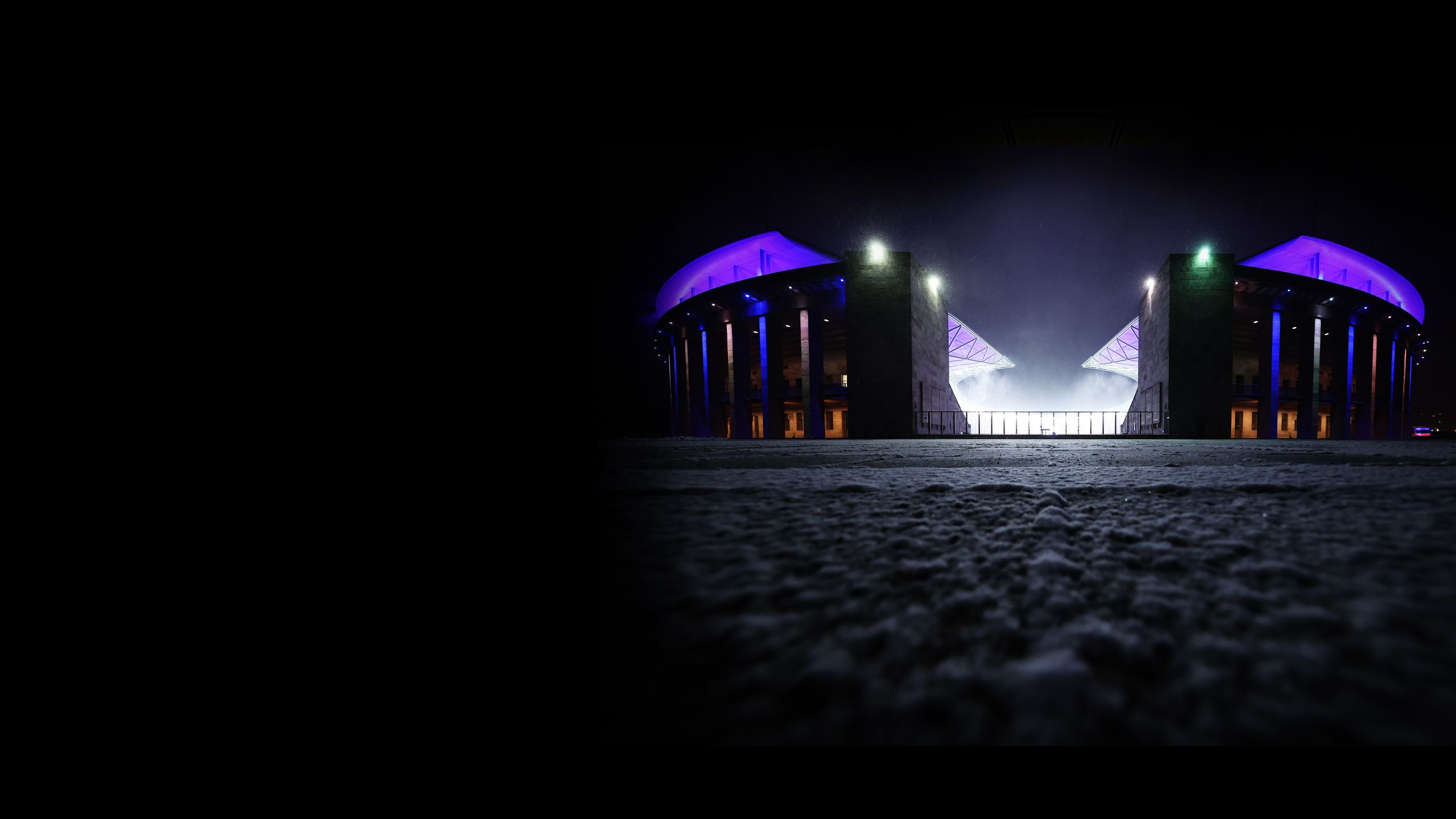 Snow on the ground in an exterior shot of Olympiastadion Berlin at night