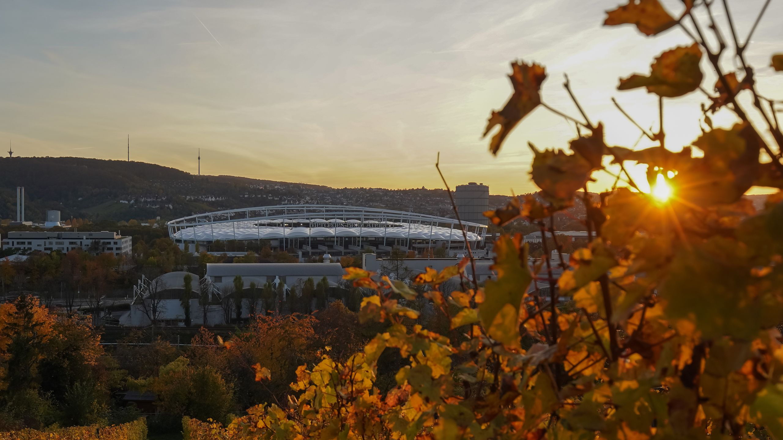 An exterior shot of the Stuttgart Arena, lit by sunlight