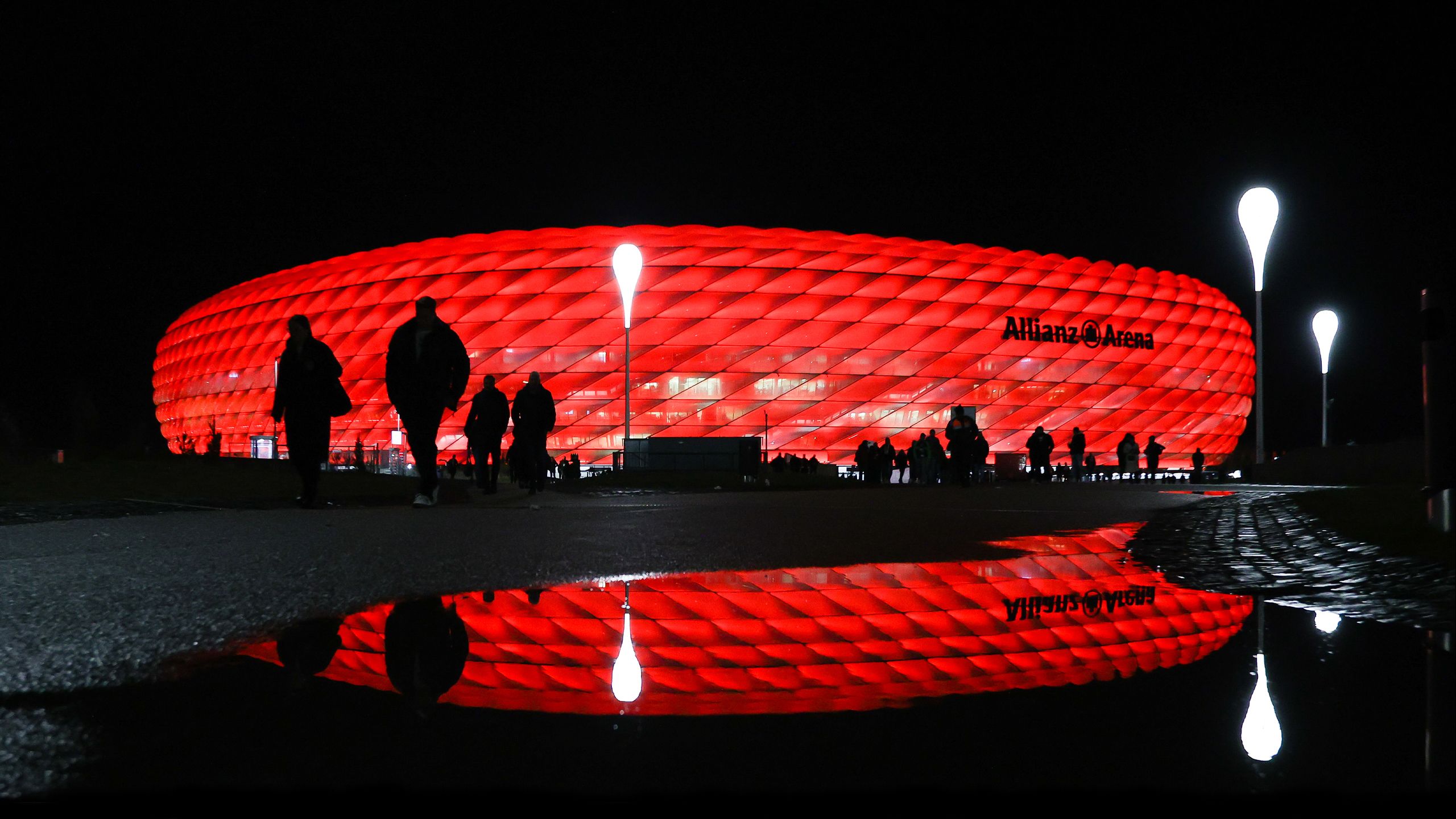 Fans walk towards the stadium in Munich, lit up in red