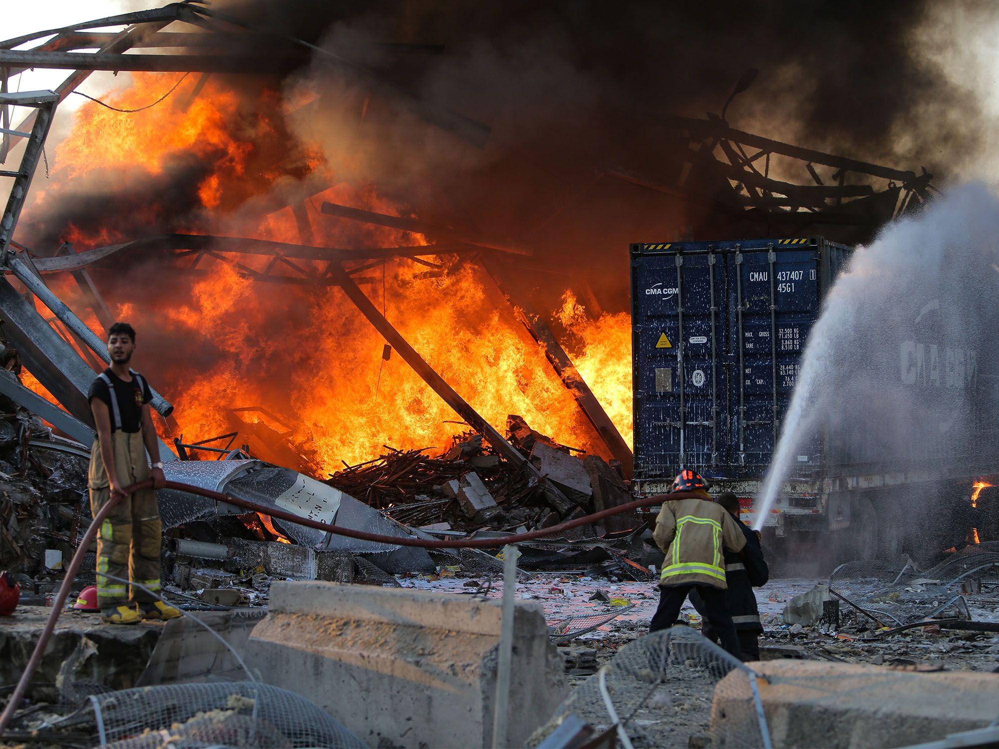 Firefighters douse a blaze at the scene of an explosion at the port