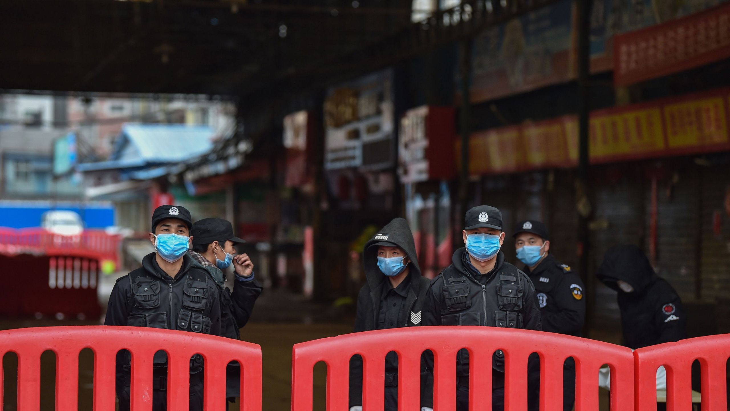 Полицейские возле оптового рынка морепродуктов в Хуанане