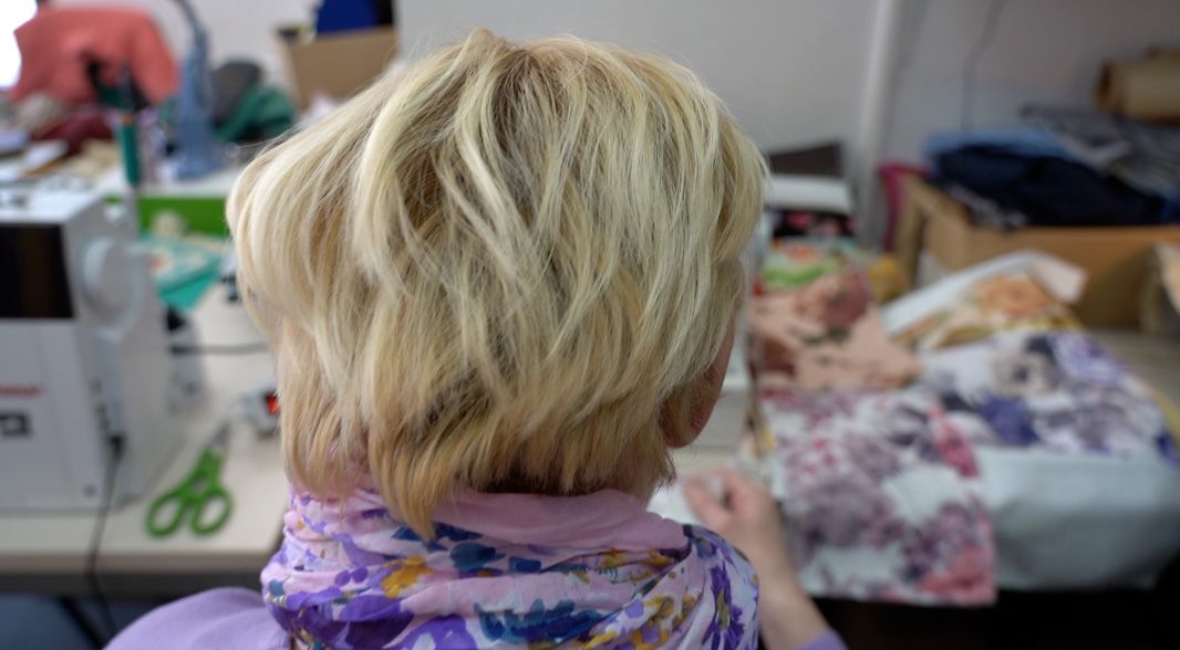 Rehanina glava, sleđa; Oko nje materijal za šivenje.