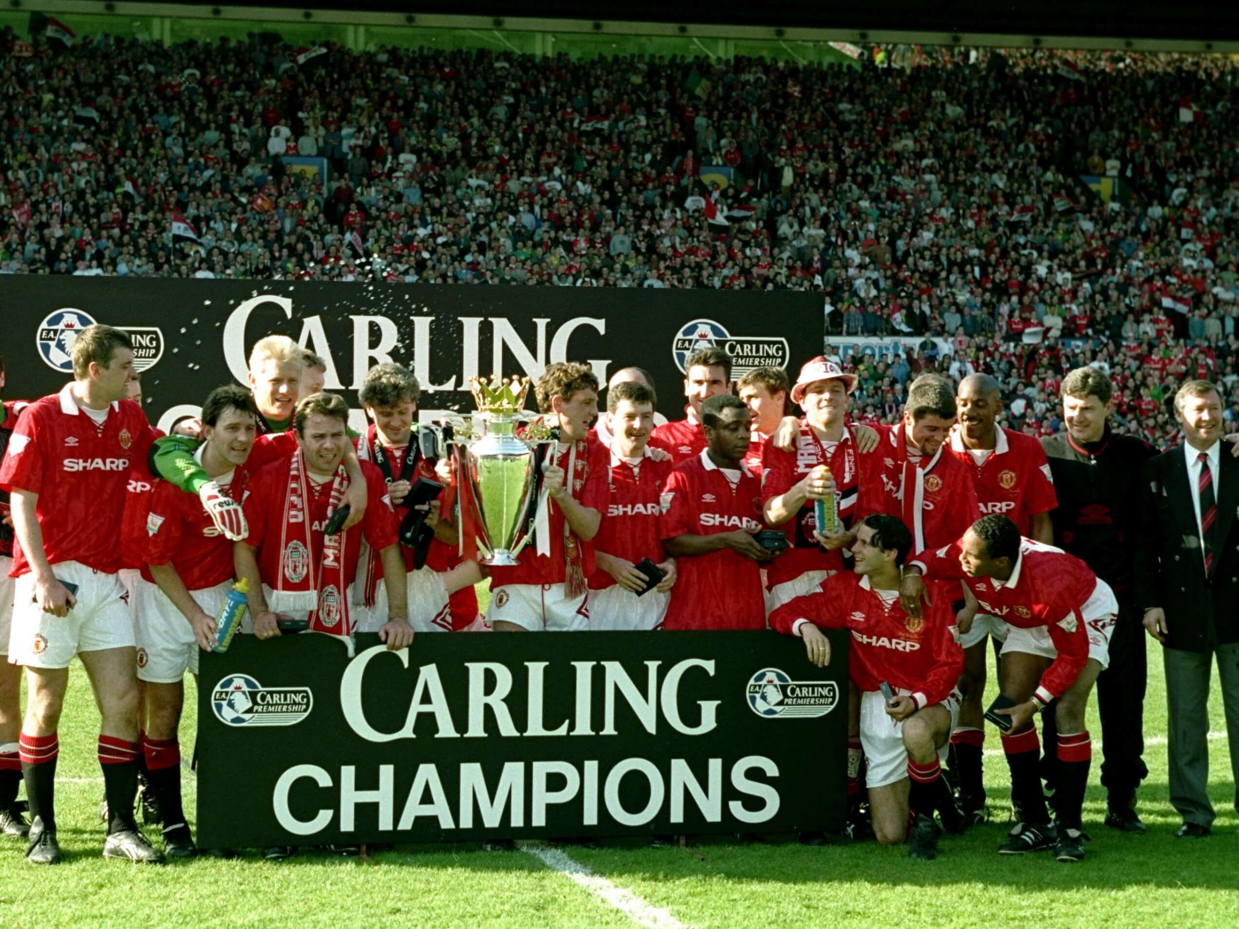 Manchester United players celebrate with the Premier League trophy after their title win in 1994