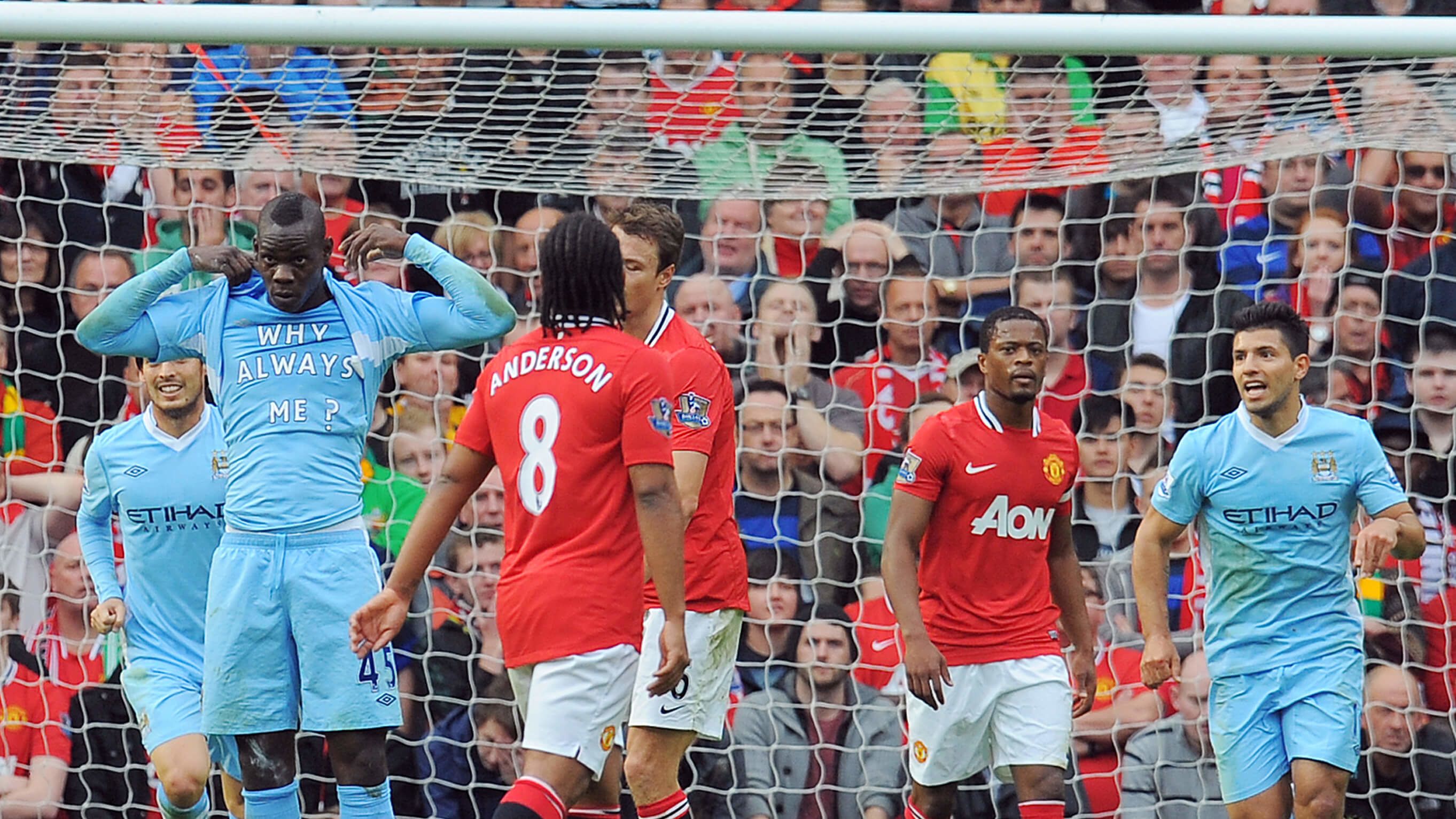 Mario Balotelli lifts his shirt to reveal a 'Why always me?' T-shirt during Manchester City's 6-1 win at Manchester United on 23 October 2011