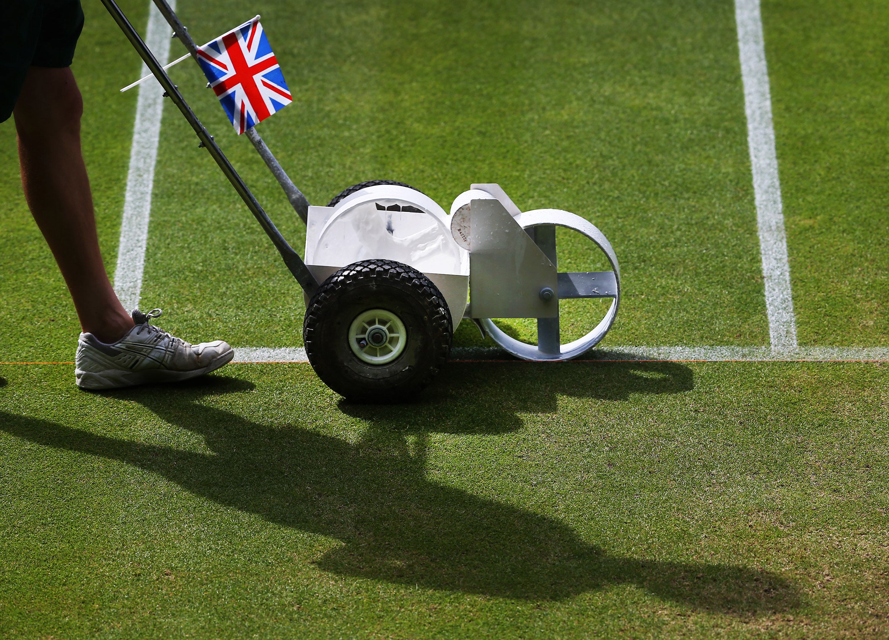 A line-painting machine, with a British flag taped to it, prepares Centre Court before the 2013 men's final