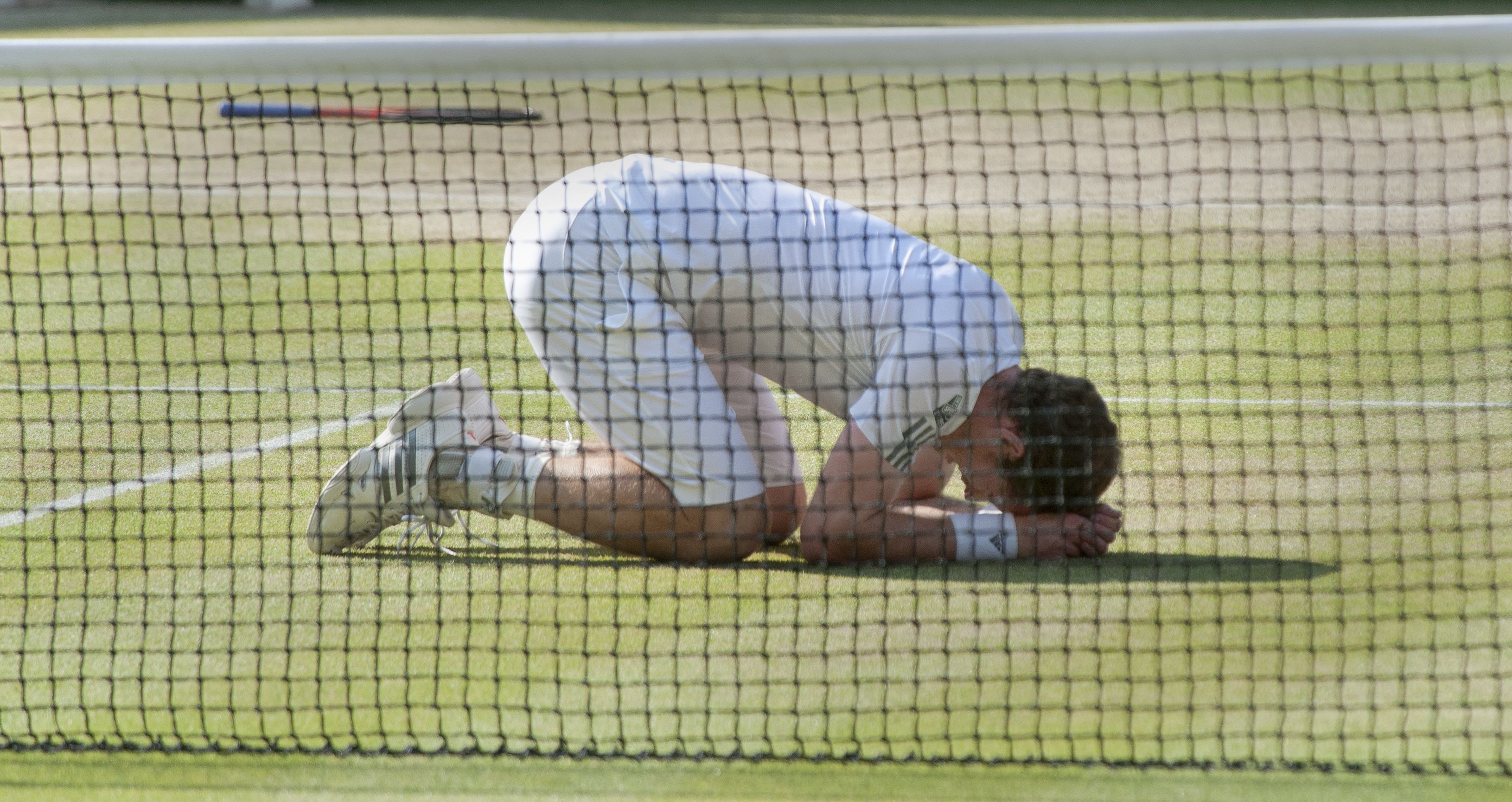 Andy Murray kneels down on Centre Court after winning Wimbledon