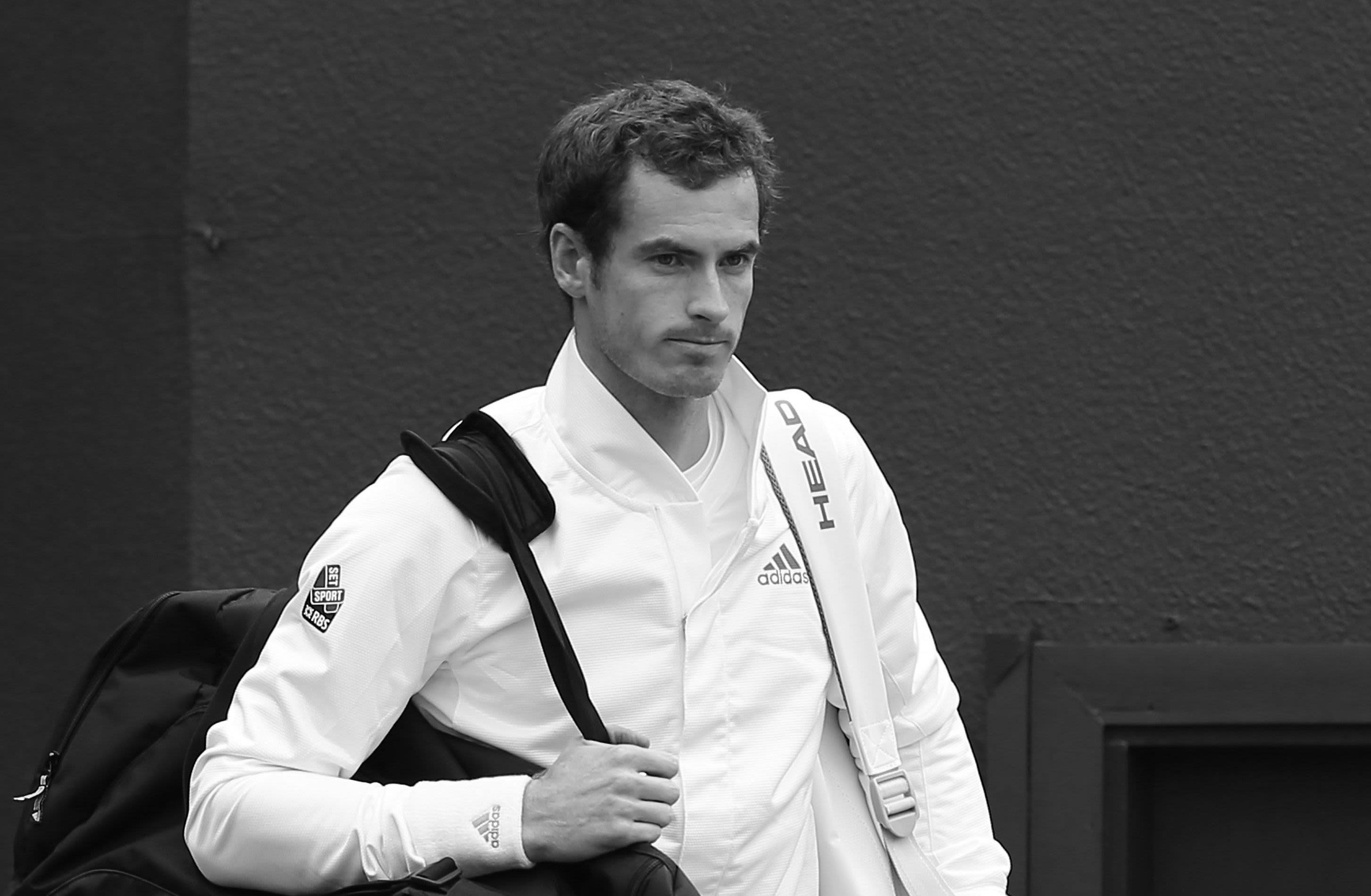 Andy Murray looks pensive as he carries his bags onto Centre Court