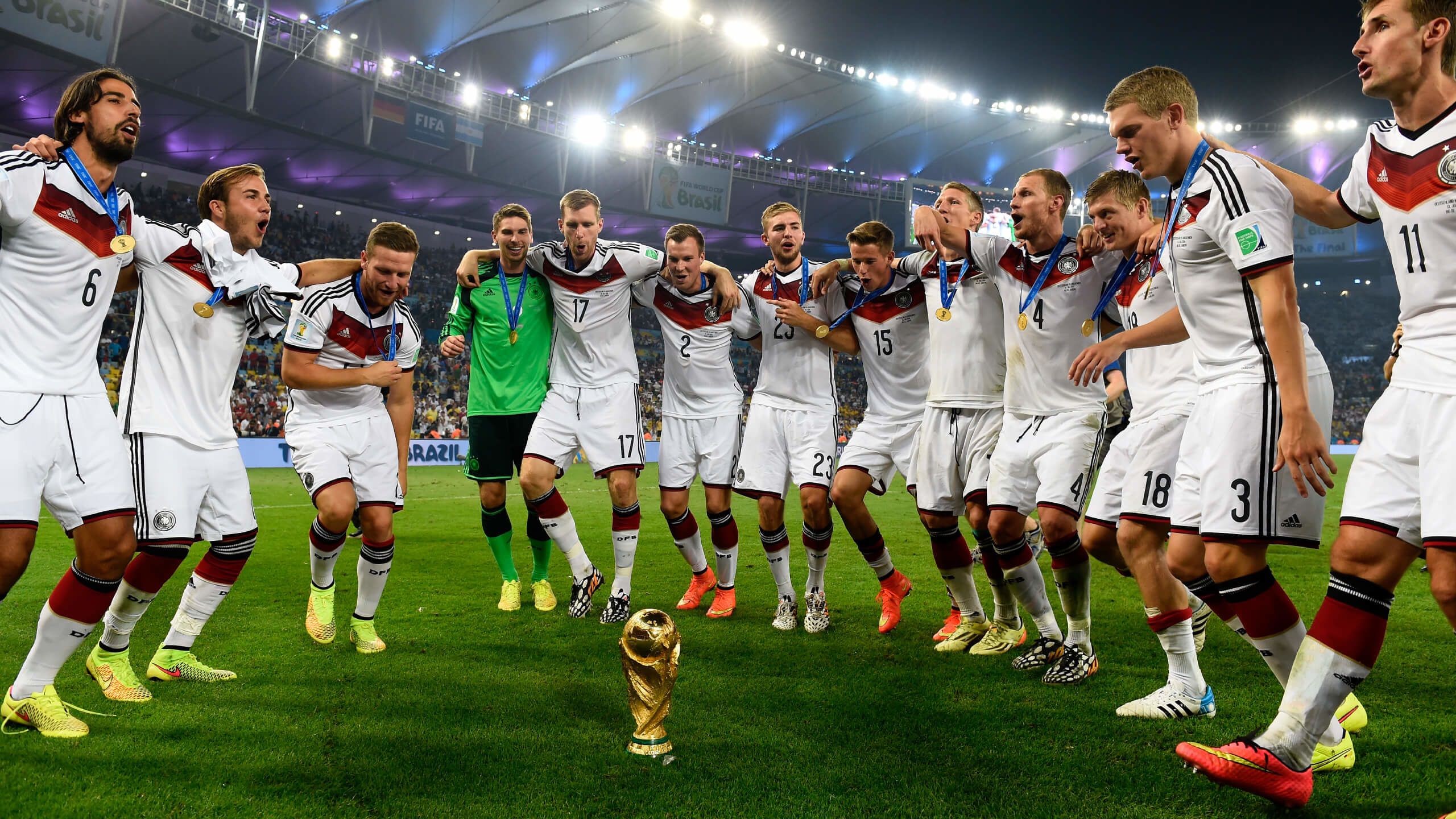 Germany players dance around the World Cup trophy in 2014