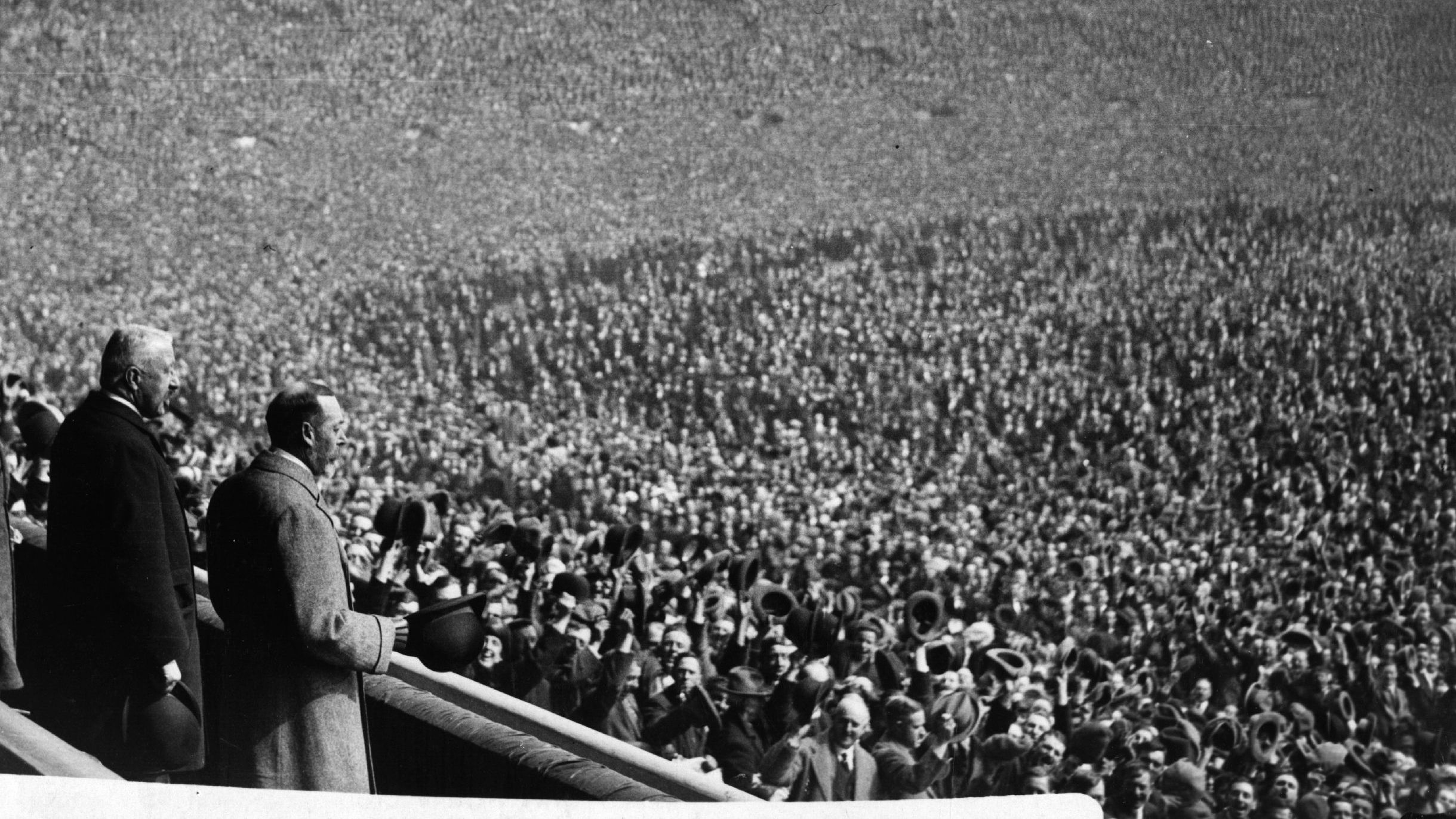 King George V watches as thousands of fans occupy the playing surface at the stadium of Wembley ahead of the 1923 FA Cup final