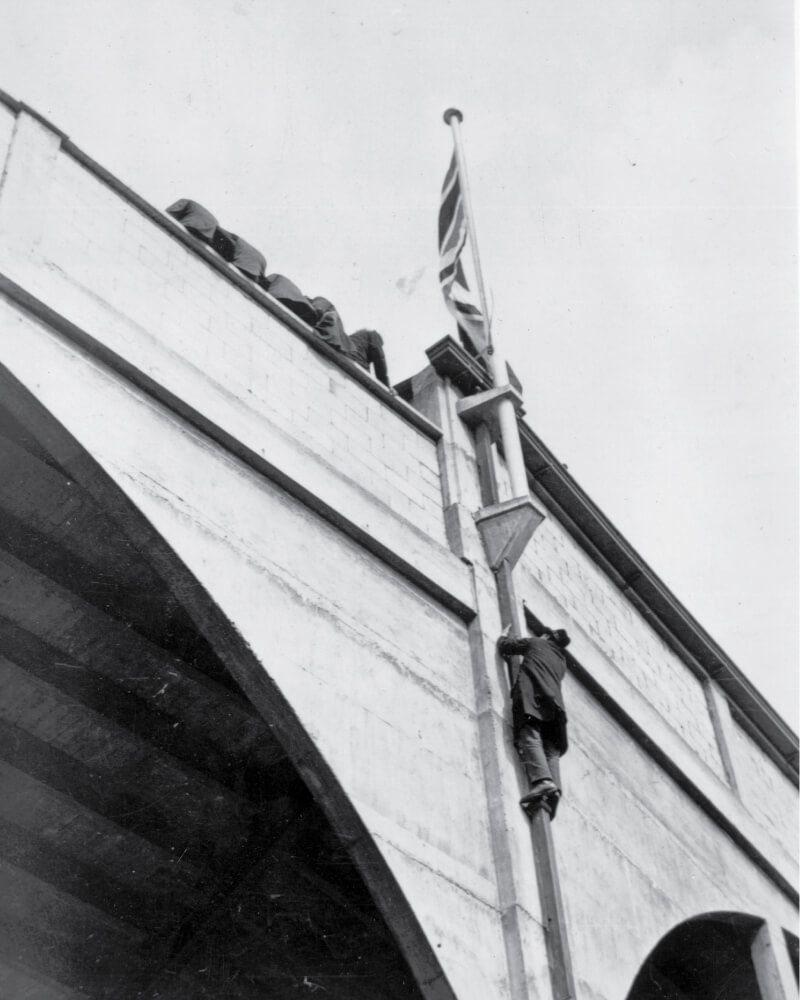 A fan claims an exterior pipe to get access to the stadium at Wembley ahead of the 1923 FA Cup final
