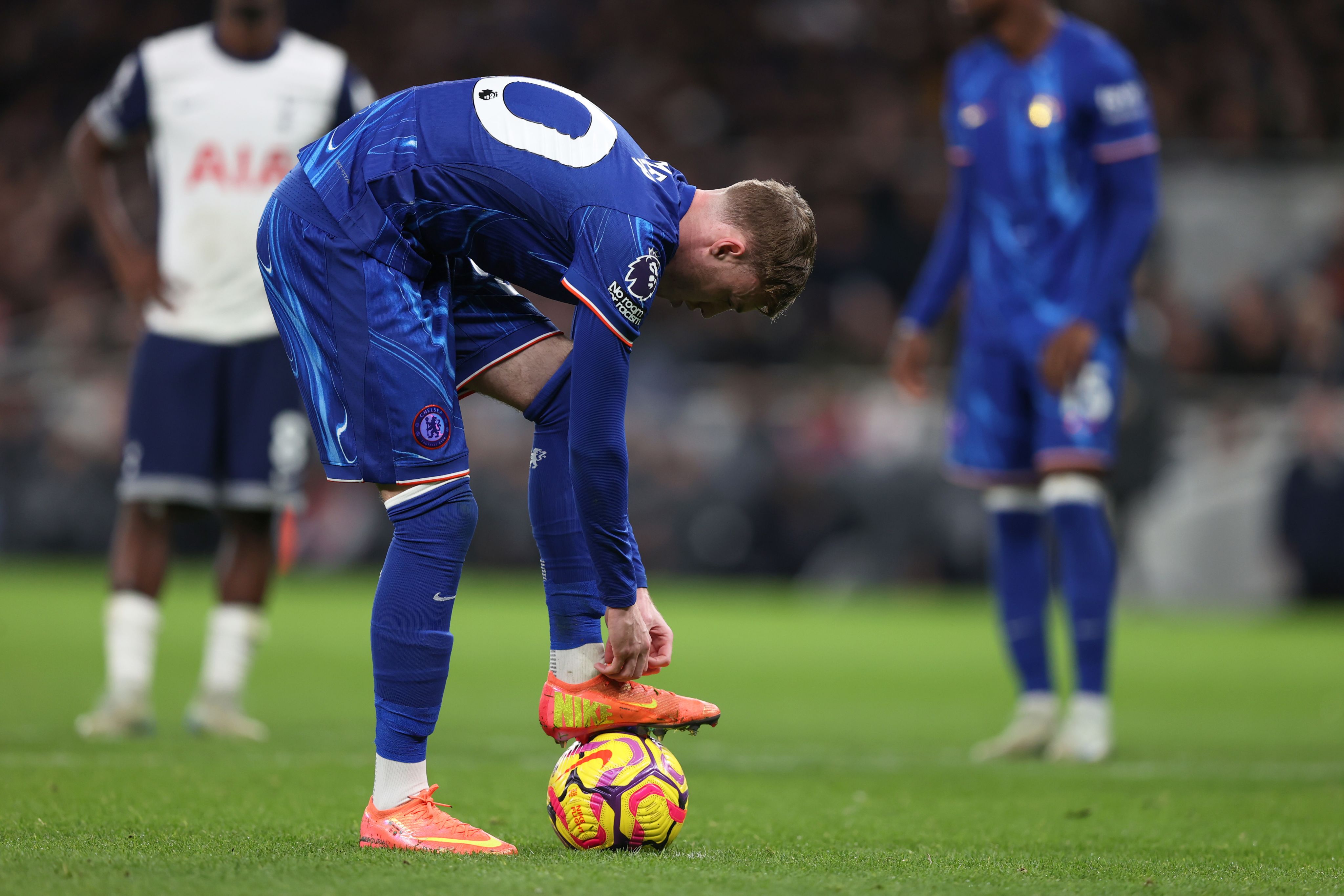 A image of Cole Palmer lacing up his boots on the penalty spot