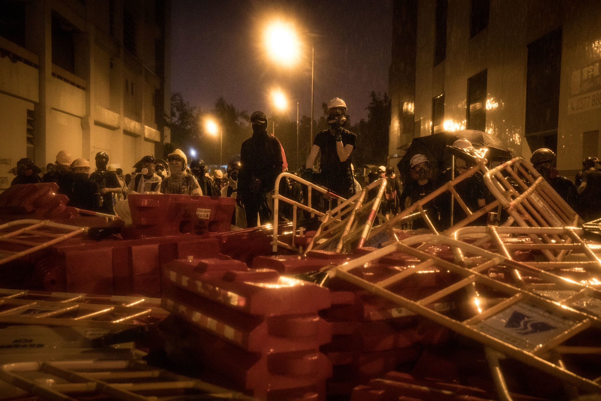 Protesters stand at the barricade at night