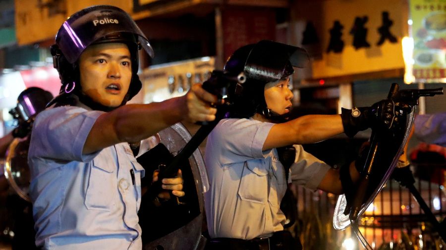香港新界荃灣街頭兩名身穿防暴裝備之警員以佩槍指向群眾（25/8/2019）（圖片來源：Reuters）