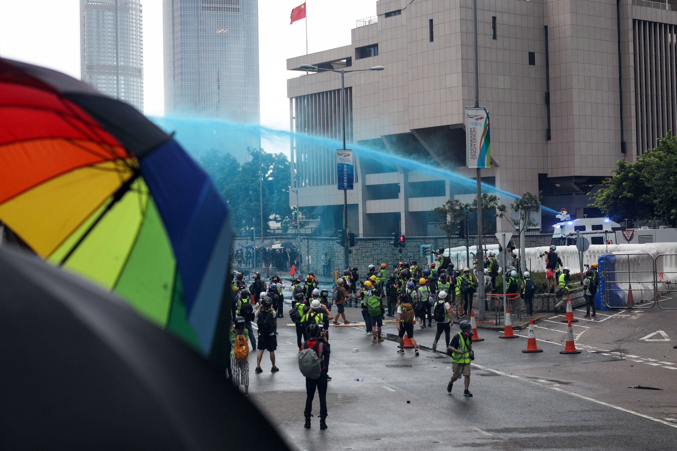香港政府總部西翼與中國解放軍駐港部隊總部外一輛警察水炮車向「反送中」示威者噴灑藍色染料(31/8/2019)(圖片來源:EPA)