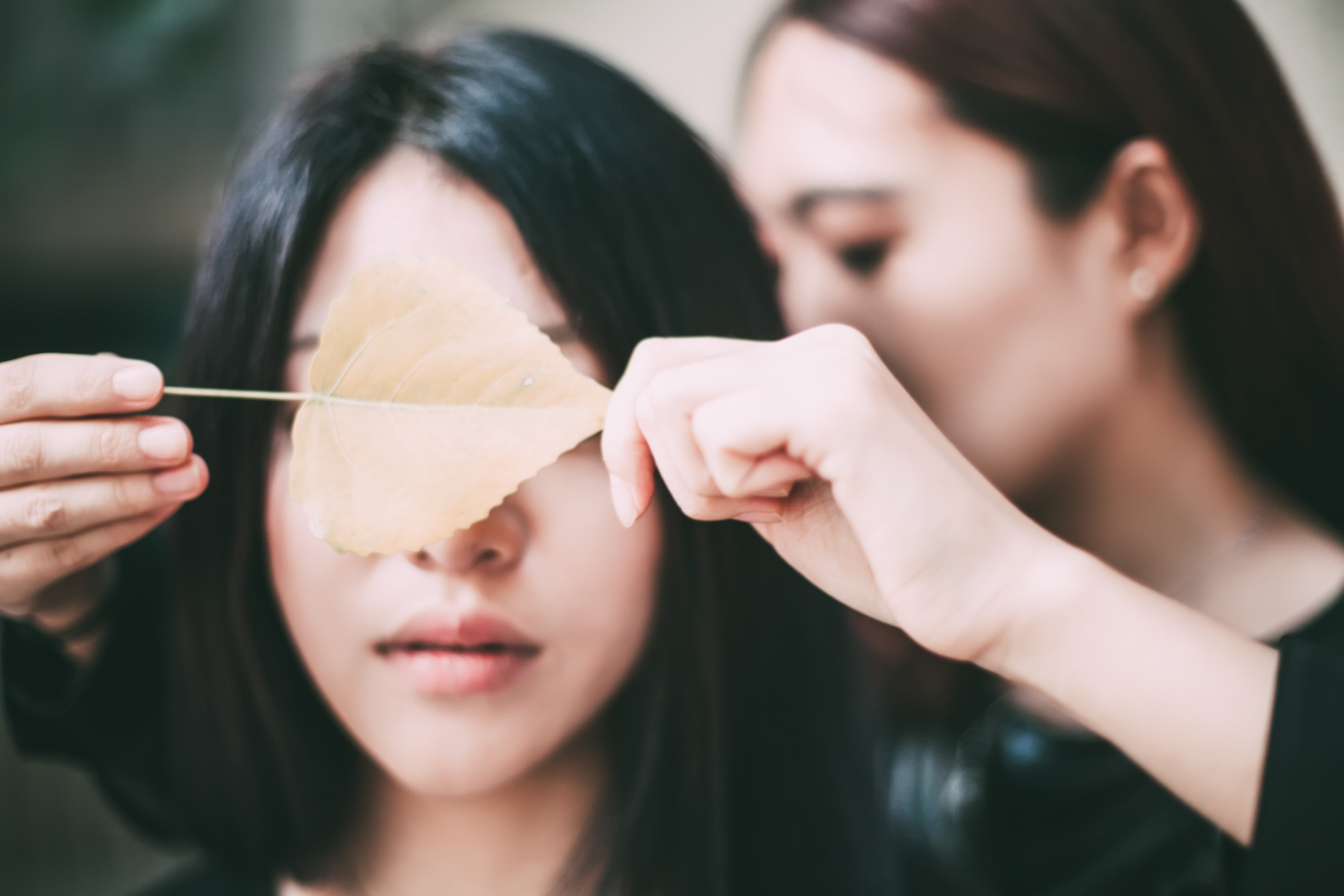 Mujer con una hoja junto a otra