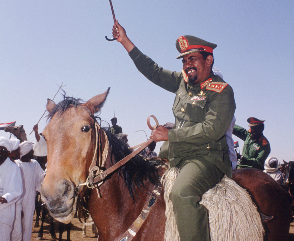 Sudan's Presdent Omar al-Bashir rides a horse greeting supporters in 1992 