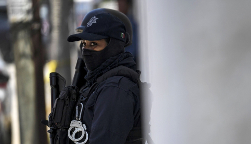 A police officer stands guard outside a bar in Mexico