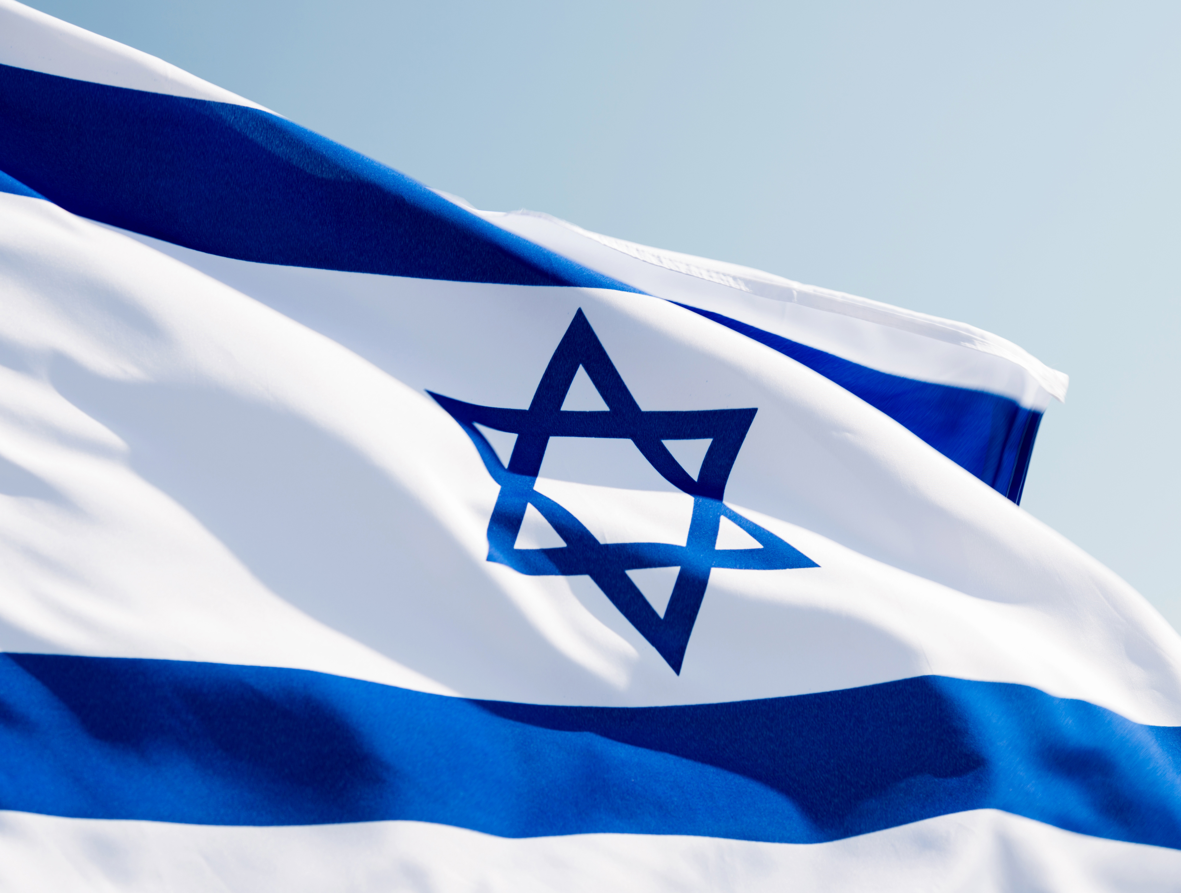 An Israeli national flag and an Islamic crescent seen on top of a mosque