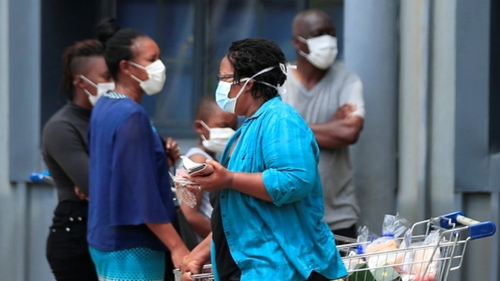 A woman leaves a supermarket in Harare, Zimbabwe