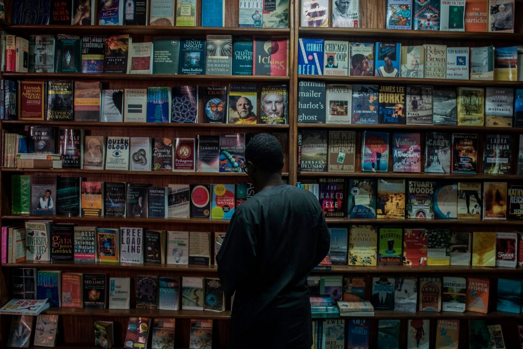 A man looking at a book shelf