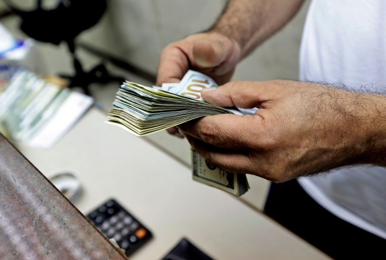 The hands of a man counting US dollars