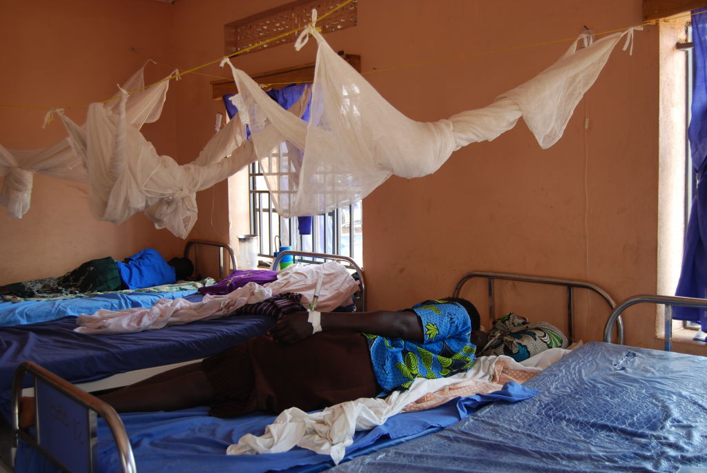 Patients lie under mosquito nets in a health facility in Uganda