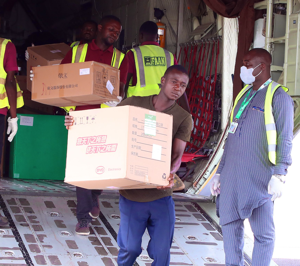 Un hombre baja una caja de donaciones de un avión 