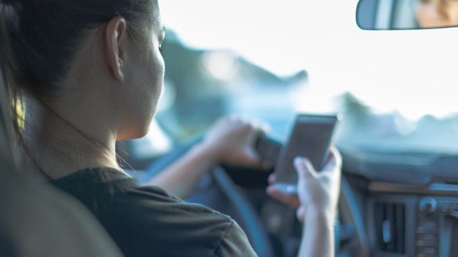 Woman using her phone while driving