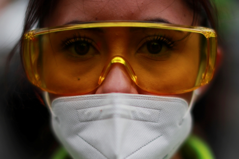 A paramedic takes part in a minute of silence in honor of their colleagues who have been killed by the coronavirus disease (COVID-19), at the Angel of Independence monument in Mexi