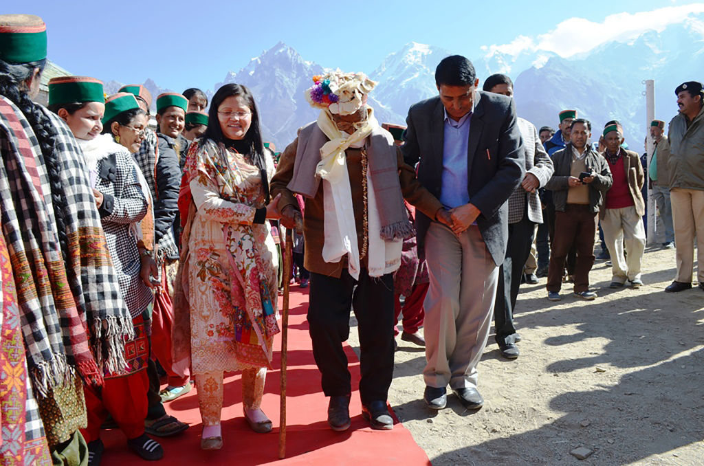 Indian voter Shyam Saran Negi (C), 100, arrives to vote in the state elections in 2017.