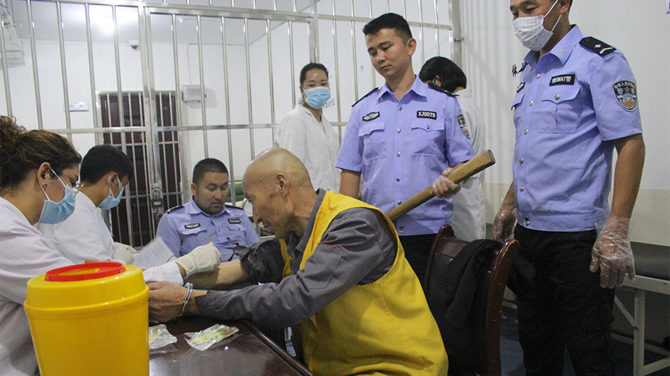 A detainee in handcuffs receiving medical care